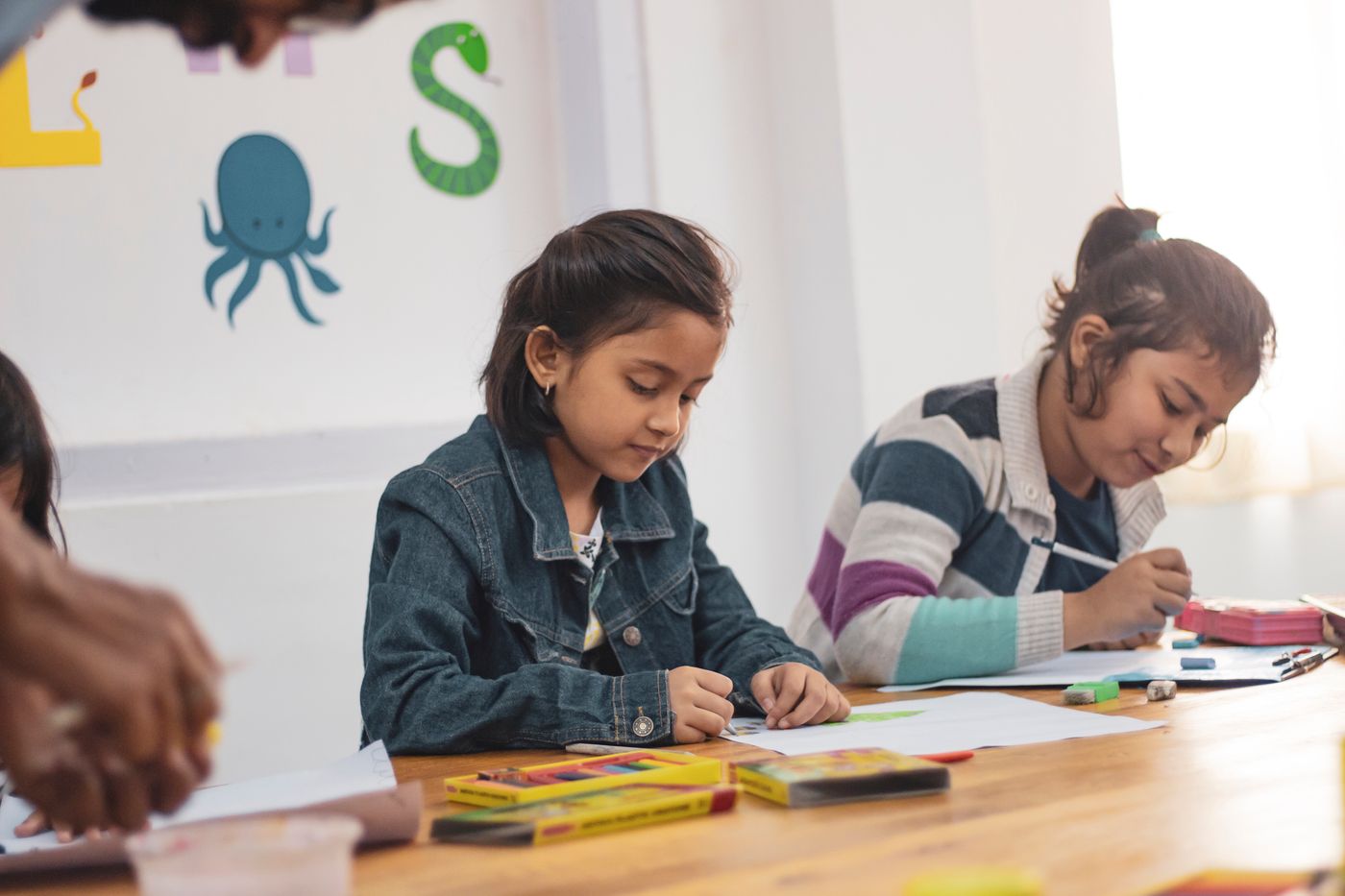 Two girls concentrating on their drawings during an art class