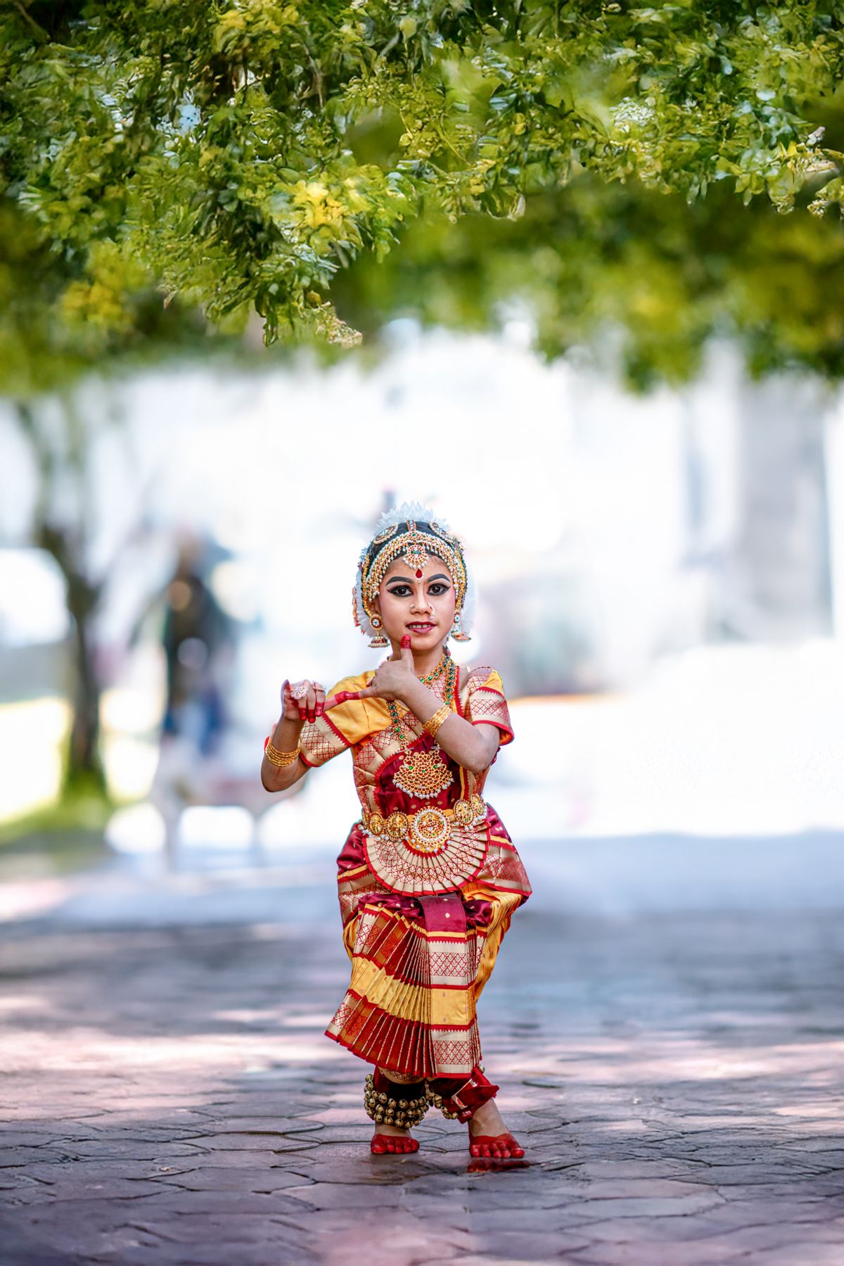 A young girl in a traditional costume performing a Bharatanatyam pose
